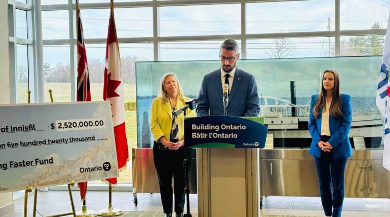 Matthew Rae, Parliamentary Assistant to the Ontario Minister of Municipal Affairs and Housing makes presents the town of Innisfil with a $2.5M cheque for exceeding their 2023 housing target (image source: X / @townofinnisfil)
